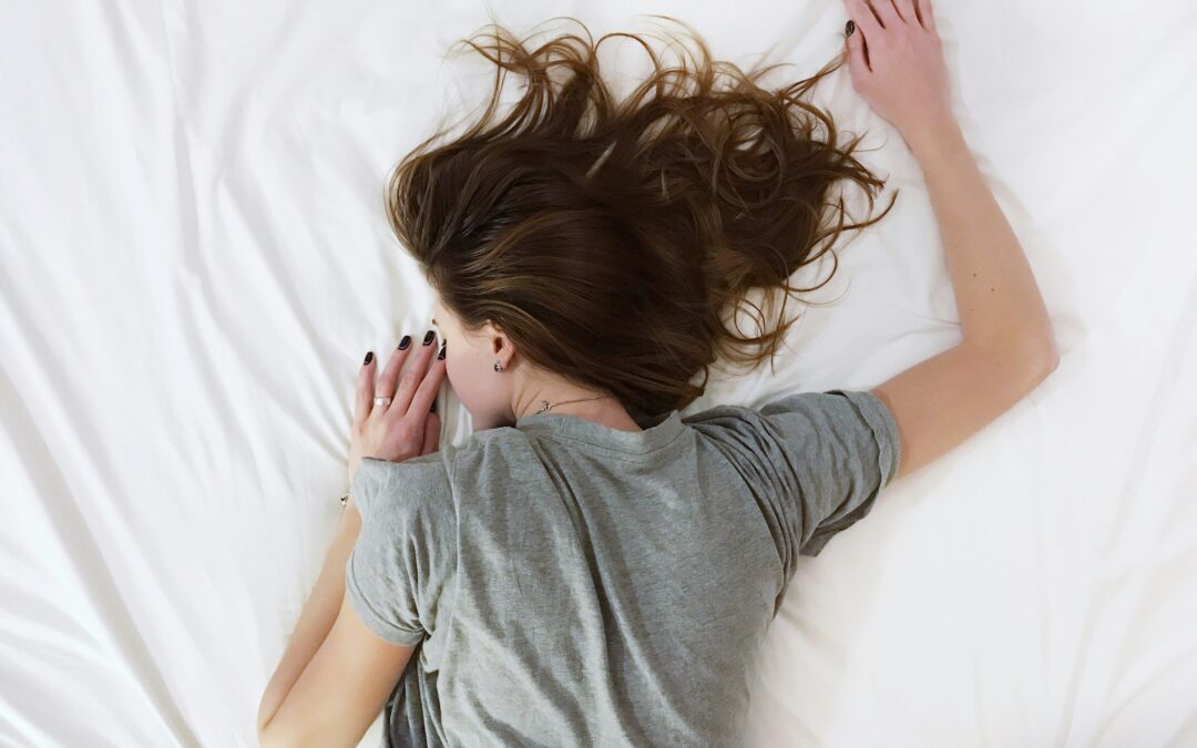 Person lying in bed looking emotionally and physically drained, illustrating why you feel exhausted during grief.